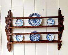 blue and white plates are arranged on a wooden shelf