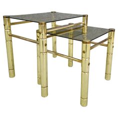 a glass table with gold bamboo legs and a black marble top on an isolated white background