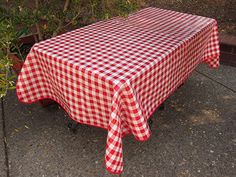 a red and white checkered table cloth sitting on the ground