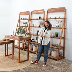 a woman standing in front of shelves with plants