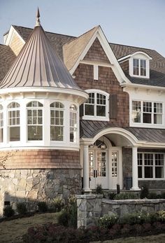 a large house with lots of windows on the front and side of it's roof