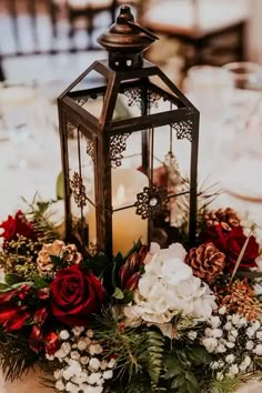 a lantern is sitting on top of a table with flowers