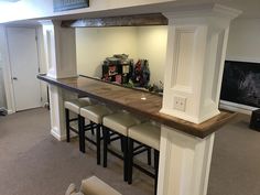 a bar with stools is in the middle of a room