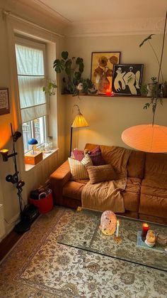 a living room with a couch, coffee table and other items on the floor in front of a window