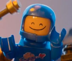 a lego man holding a hammer and smiling