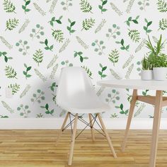 two white chairs sitting in front of a table with a plant on it's side