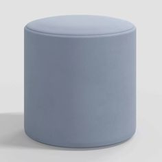 a light blue stool sitting on top of a white floor next to a gray wall