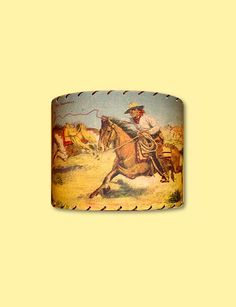 a lamp shade with an image of a cowboy riding a horse in the desert on it