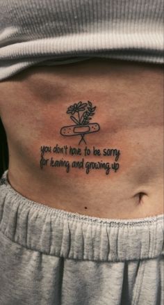 a woman with a tattoo on her stomach saying you don't have to be sorry for having and growing up