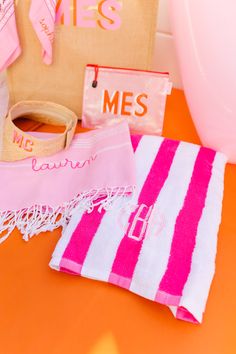 pink and white towels on an orange table with personalized items in the back ground