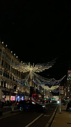 a city street is lit up with christmas lights