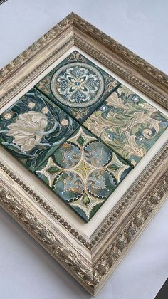 an ornate gold frame with four different designs on the sides and one is painted green