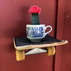 a coffee cup is sitting on top of a skateboard with a cactus in it