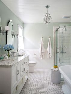 a white bathroom with two sinks and a bathtub