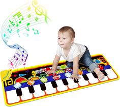 a baby sitting on top of a piano mat with musical notes coming out of it