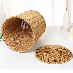 two round wicker baskets sitting on top of a white table next to a vase