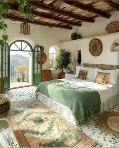 a large bed sitting under a window in a bedroom next to a doorway and potted plant