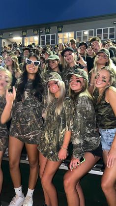 a group of women in camo outfits posing for a photo together at a sporting event