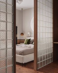 an open door leading to a bedroom with a bed in the middle and a lamp hanging from the ceiling