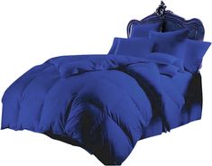 a bed with blue comforters and pillows on it