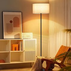 a chair sitting in front of a lamp next to a book shelf