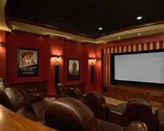 a home theater with leather chairs and a projector screen