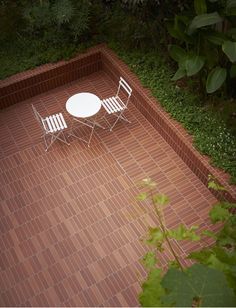 a table and two chairs sitting on top of a brick patio