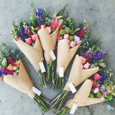 a bunch of flowers that are sitting on the ground with price tags attached to them