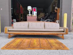 a couch sitting on top of a rug in front of a garage