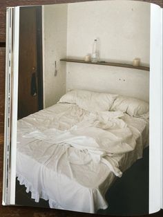 an open book showing a bed with white sheets