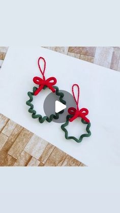 an ornament made out of felt and ribbon on top of a piece of paper