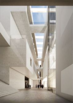 people are walking through an empty building with skylights on the ceiling and stairs to the second floor