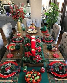 a dining room table set for christmas dinner with red and green decorations on the table