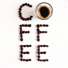 the word coffee spelled with beads next to a cup of coffee on a white surface