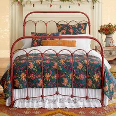 the bed is made up with colorful flowers on it and white linens, along with decorative garland