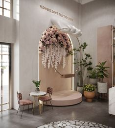 a living room with flowers on the wall and tables in front of it that have chairs around them