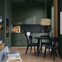 a kitchen with green walls and wooden flooring is pictured in this image, there are three chairs around the table