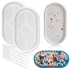 three plastic trays with spoons and forks next to each other on a white background