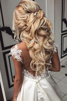 the back of a woman's wedding dress, with long blonde hair in it