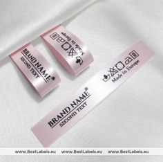 two brand name labels on a white shirt with pink ribbon around the neck and bottom