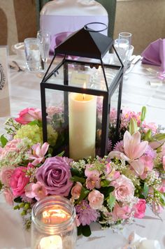 a table topped with a lantern and flowers