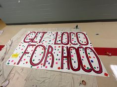 a large sign that says get loose for hoo on the floor with confetti all over it