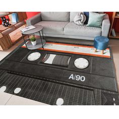 a rug with an audio tape on the floor in front of a couch and coffee table