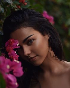 a woman is posing with flowers in her hair