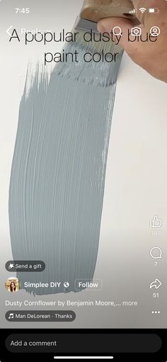 a person is painting the wall with gray paint on their phone screen and text reads, a popular dusty blue paint color simple diy e follow