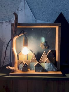 a wooden table with a lamp on top of it and some houses in the background