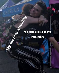 two people hugging each other in front of a tent with the words yungblu's music on it