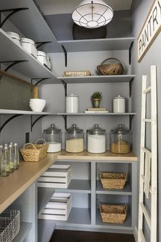 an organized pantry with shelves, baskets and other items on the counter top in front of a light fixture