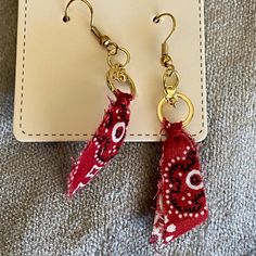 two pairs of red and white fabric earrings with gold hooks on top of a card