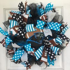 a football wreath on the front door decorated with blue and white polka dots, black and brown mesh